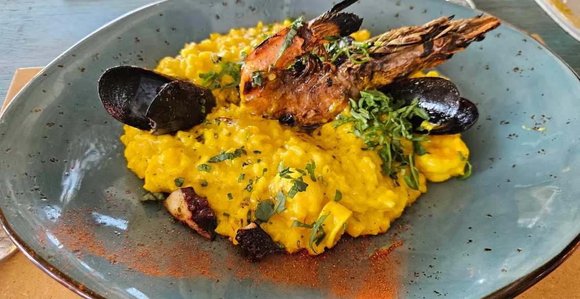 Alt: Risotto de mariscos con langostinos mejillones y pulpo en Alimar Quito.