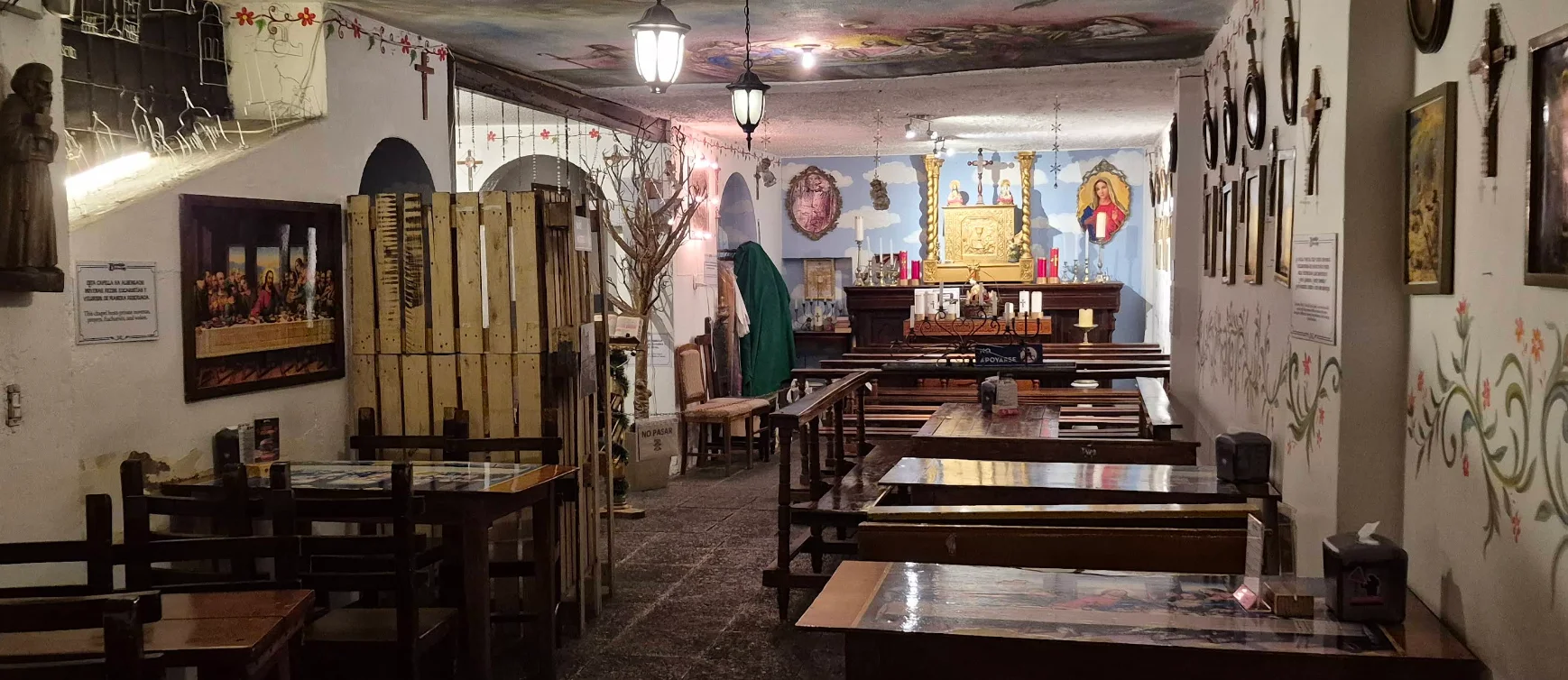 Interior de la cervecería Bandido Brewing en Quito con temática de capilla, mesas de madera, bancos tipo pews y arte religioso colonial.