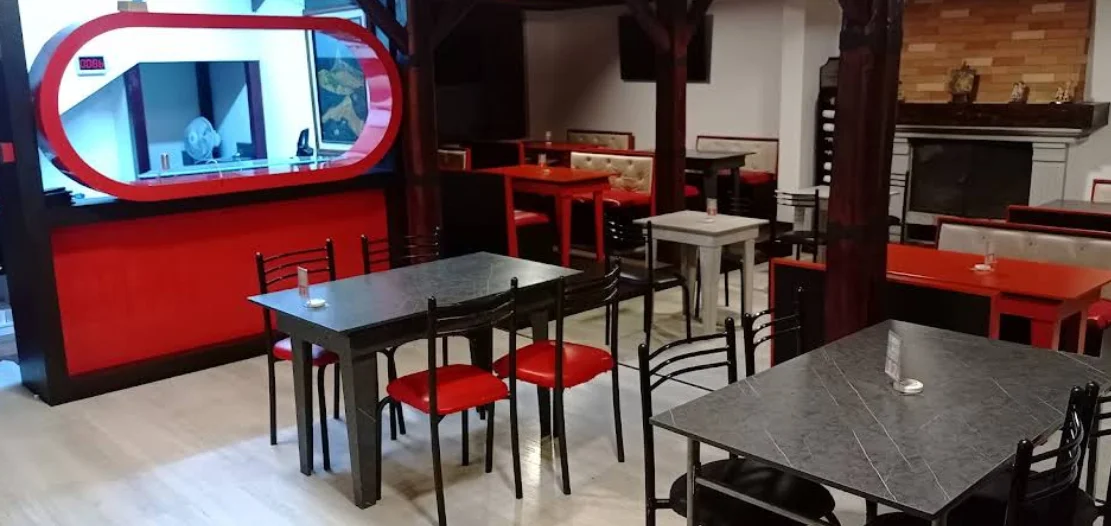 Ambiente interior de Chorigol Cumbayá con mesas y sillas en negro y rojo.