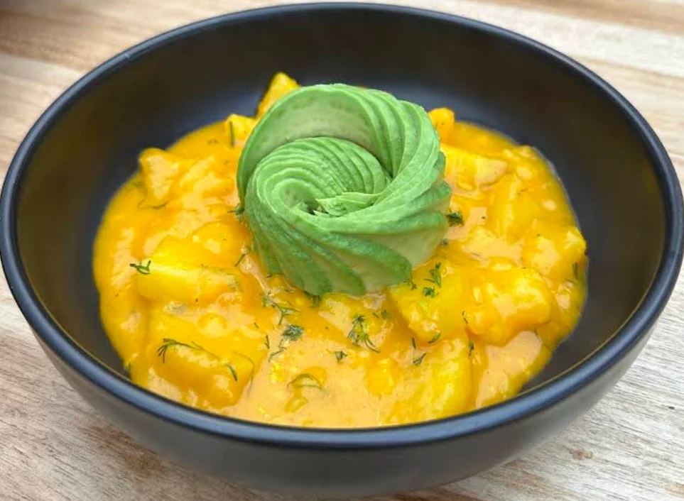 Ceviche de mango con una rosa de aguacate en bowl negro en Claroscuro Gastro Bar Quito.