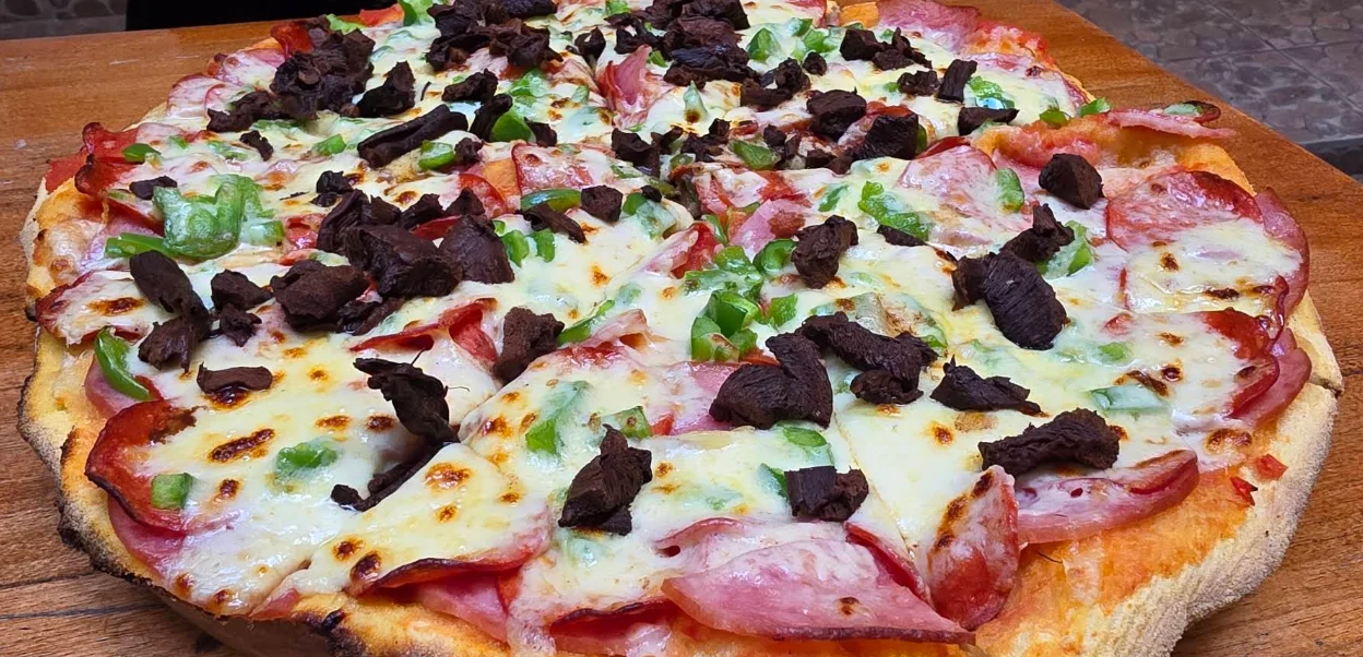 Pizza artesanal de masa madre con jamón, salami y carne seca en Del Bacino, pizzería del Centro Histórico de Quito.