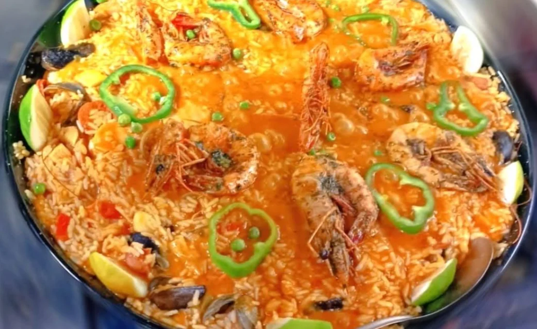 Paella de mariscos con camarones, mejillones, pimiento verde y limón servida en paellera en Don Juan Paella, restaurante de comida mediterránea en Quito.