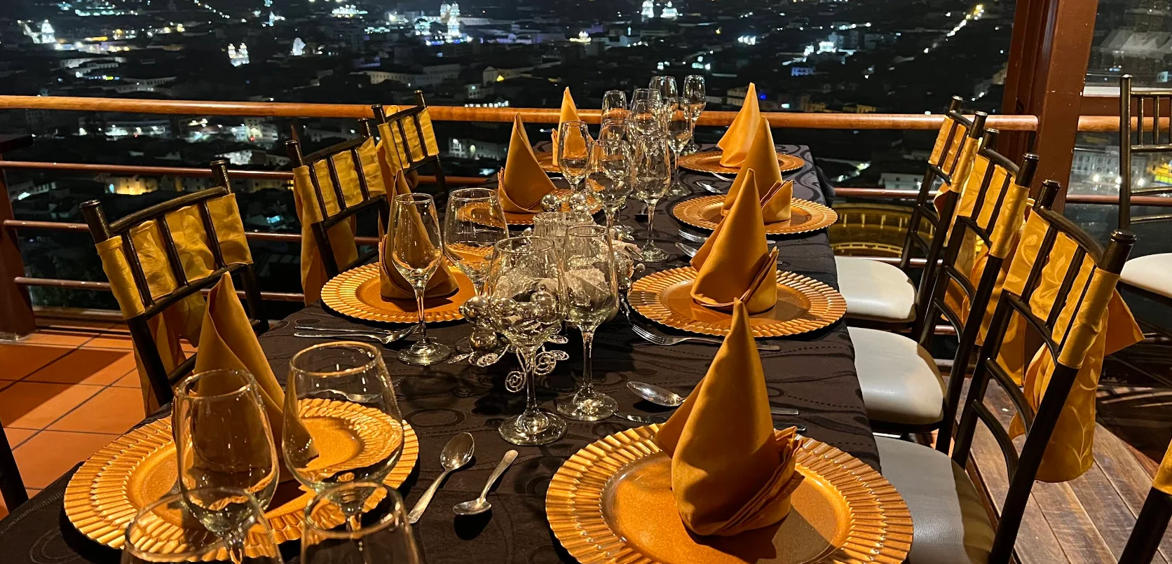 Mesa elegante en la terraza de El Escondite de Cantuña con vista panorámica nocturna de Quito.