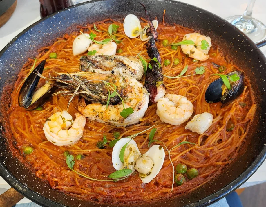 Fideuà de mariscos con camarones, mejillones, calamar y almejas en salsa de tomate en el restaurante Ignis en Quito.