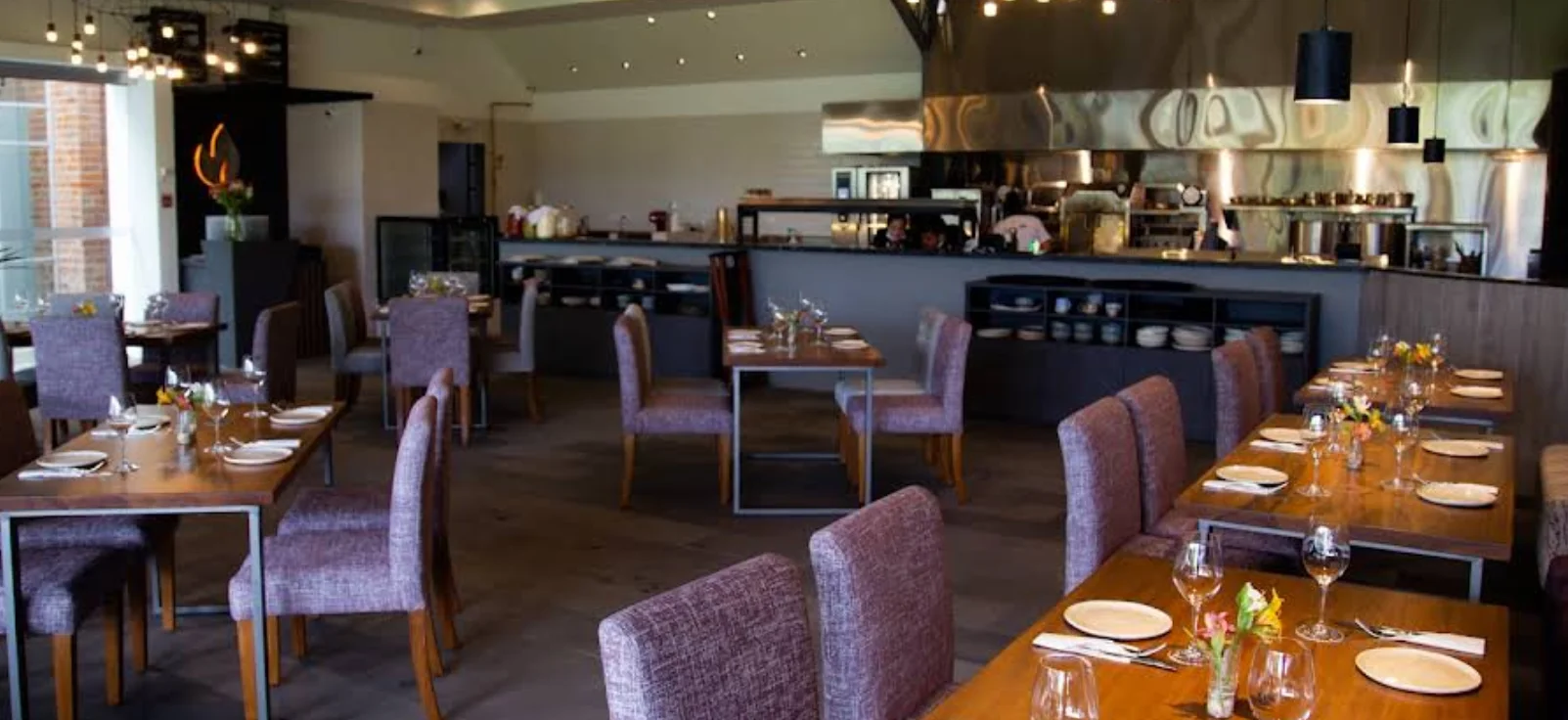 El ambiente sofisticado y acogedor de Ignis: un espacio amplio que combina elegancia rústica con una cocina a la vista de última generación. Perfecto para cenas de negocios o celebraciones especiales.