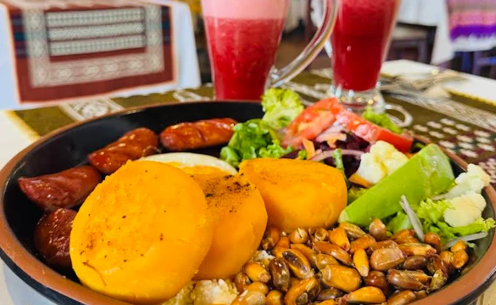 Llapingachos con maíz tostado, chorizo, ensalada y jugos naturales de mora en el restaurante La Capilla en Quito.