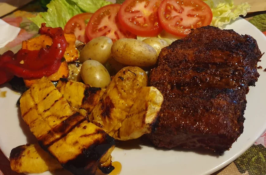 Chuletón a la parrilla con vegetales asados, papas y ensalada fresca, plato de La Carnicería en Quito