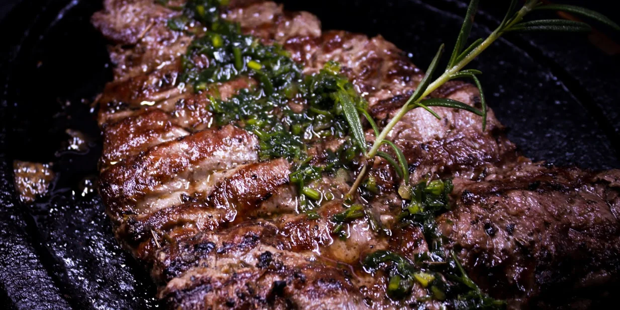 Alt: Carne a la parrilla con chimichurri en La Chimenea Restaurant Quito.