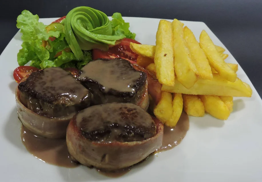 Filete de res en salsa de champiñones con papas fritas y ensalada en el restaurante La Esquina de Cantuña en Quito.