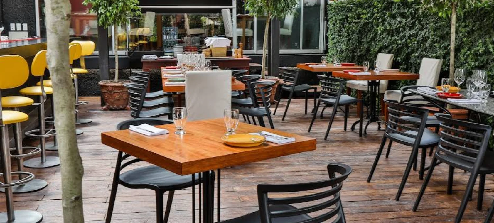 Elegante terraza del restaurante La Gloria en González Suárez, Quito, con iluminación cálida, vegetación y ambiente mediterráneo sofisticado