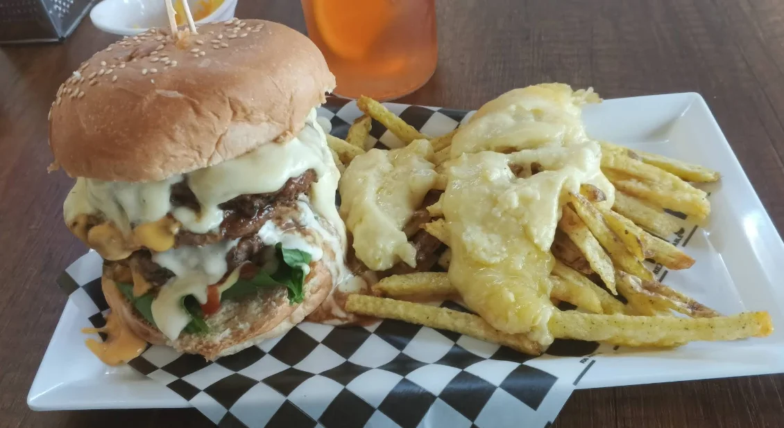 Hamburguesa con queso derretido y papas fritas con queso en Me Derrito Quito.