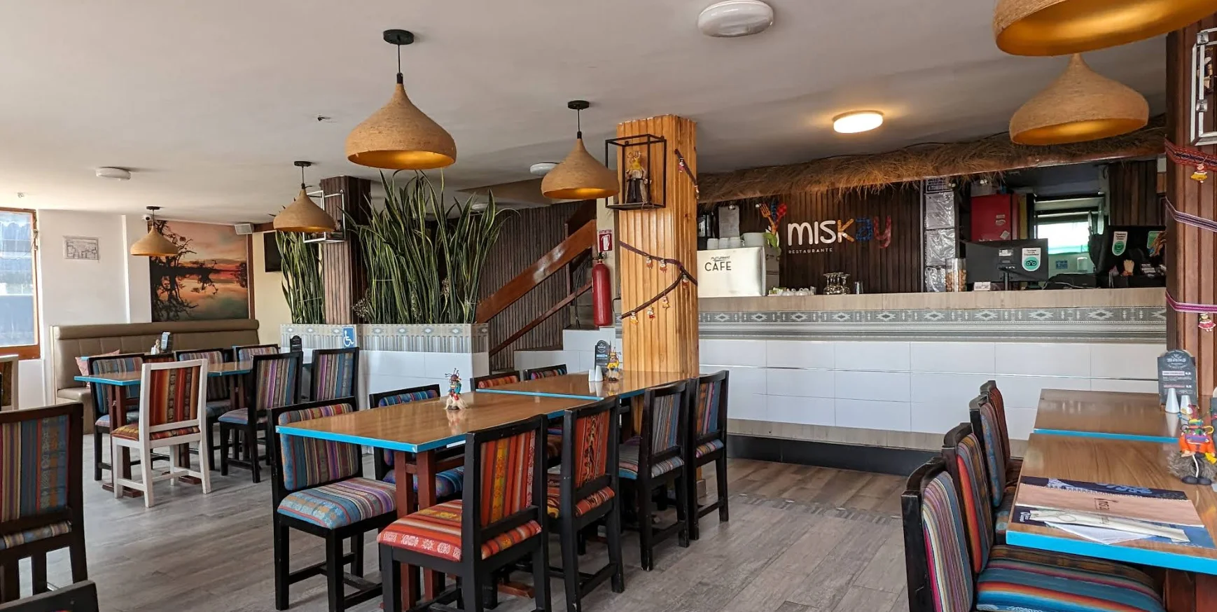 Salón principal del restaurante Miskay con sillas de diseño andino y lámparas artesanales.