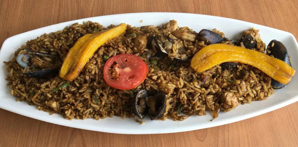 Arroz marinero con conchas, camarón y maduro frito, plato de mariscos en Puerto Andino, marisquería en Calderón, Quito.