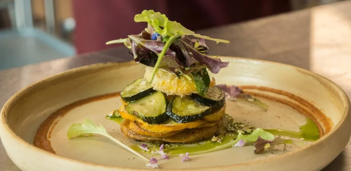 Plato gourmet con vegetales y flores comestibles en Sensibus Taller Gastronómico Quito.
