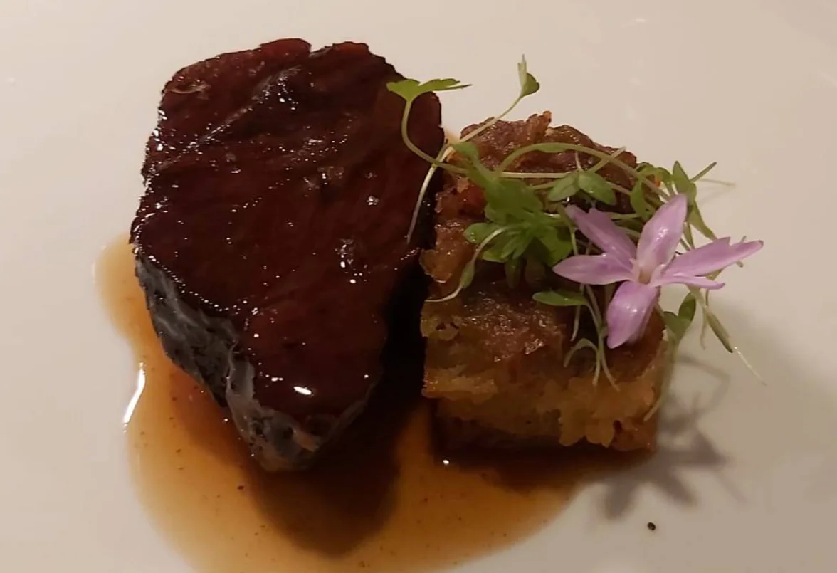 Plato de carne gourmet con glaseado y guarnición en Restaurante Zazu Quito.